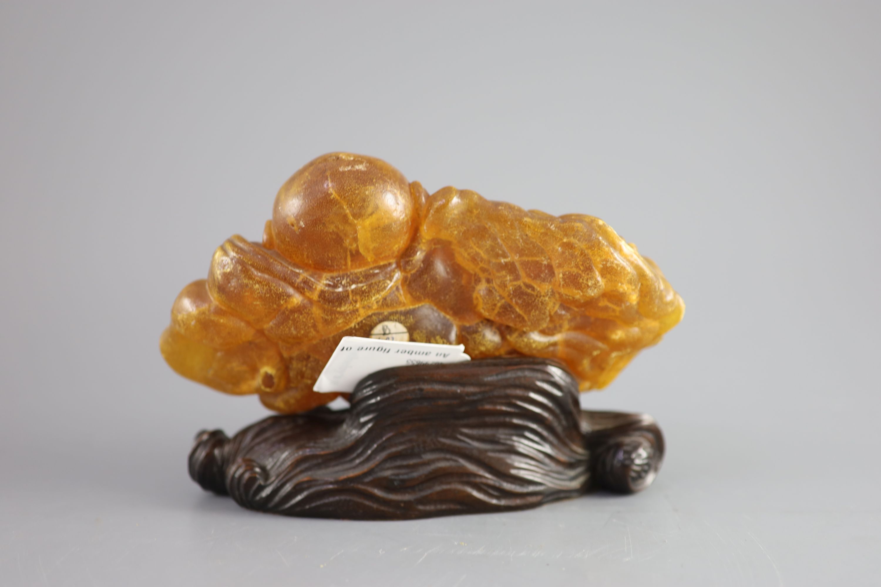 A Chinese amber figure of Buddha, 19th century, width 21.5cm